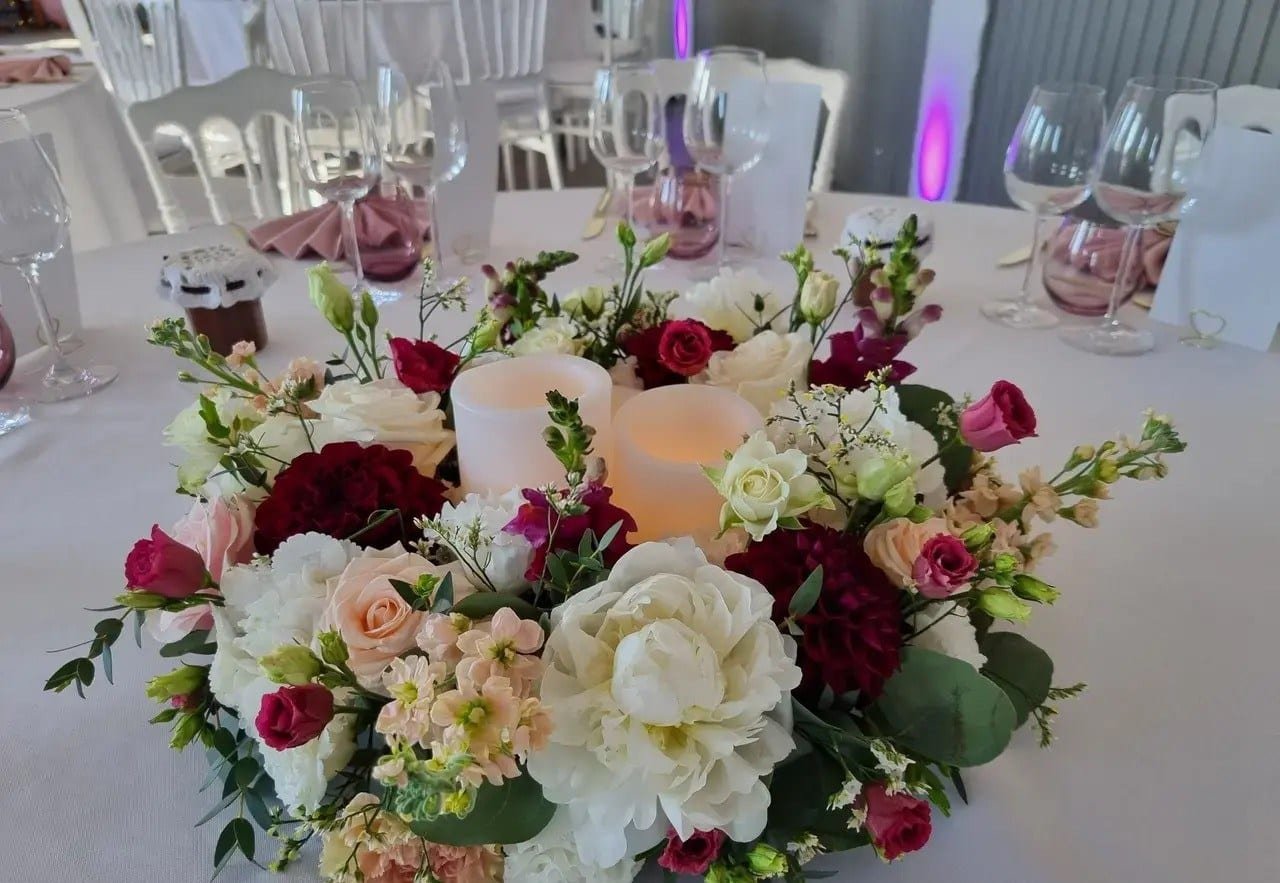 Centre de table : couronne de roses, pivoines et dahlias autour de bougies