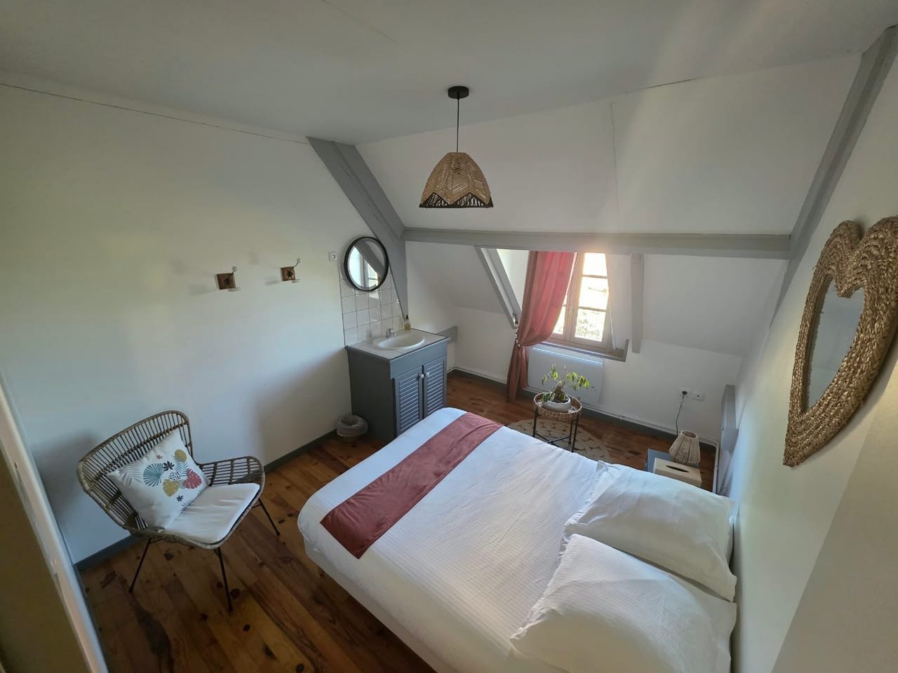 Chambre double sous les combles, tons rosés, poutres apparentes et parquet ancien