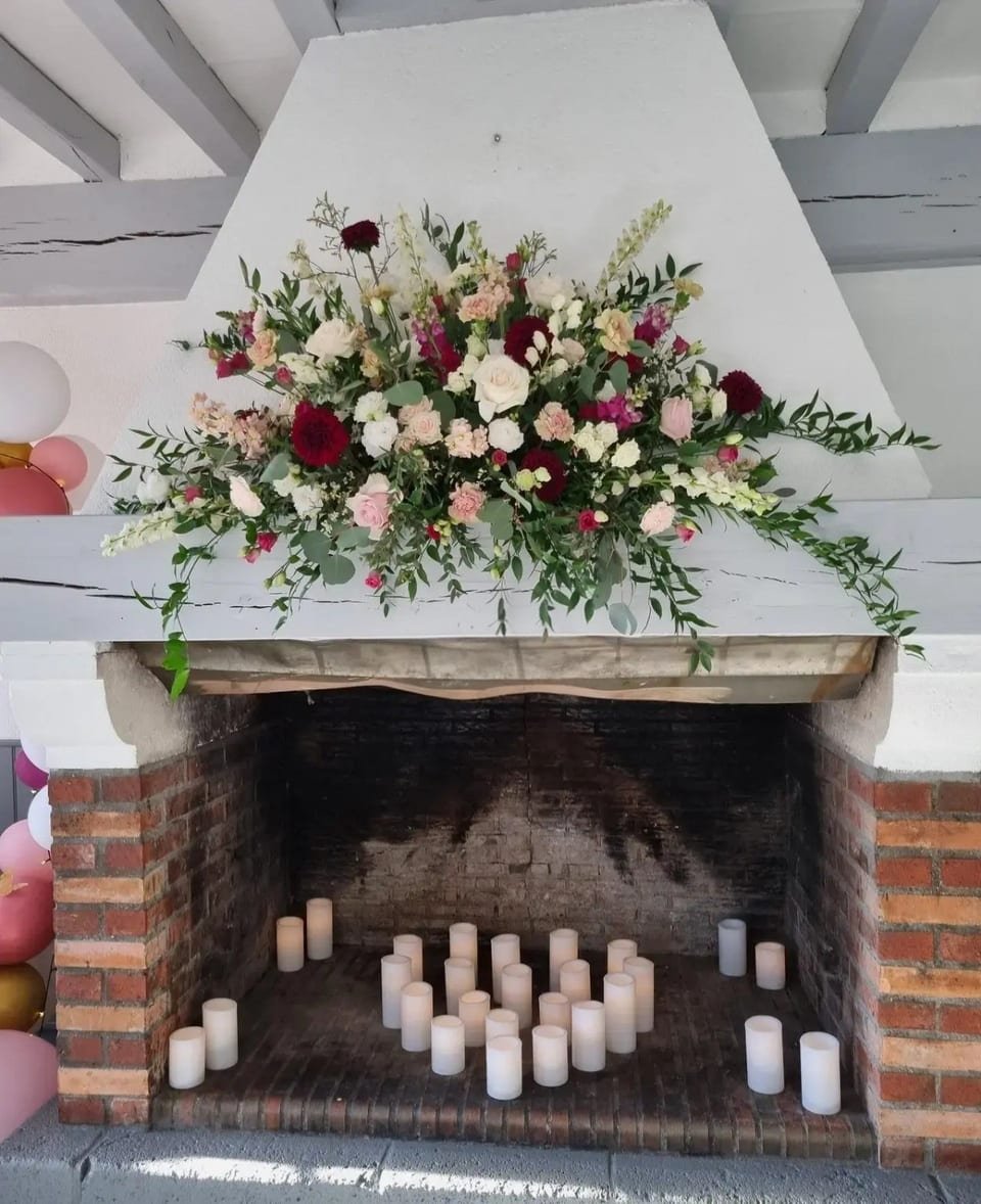 La cheminée en brique de la salle, ornée d’un bouquet et de bougies